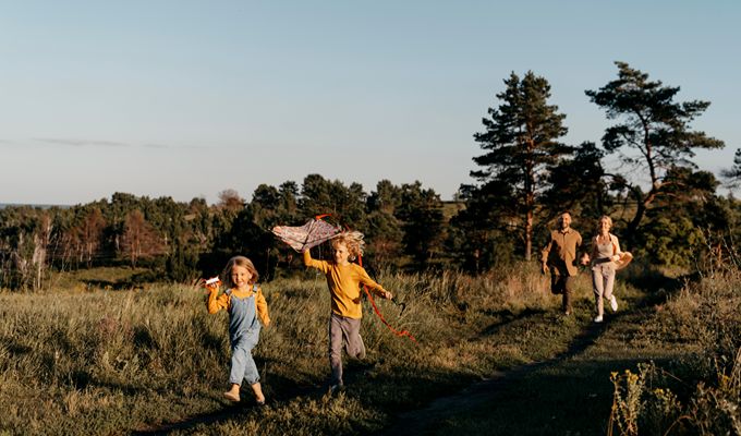 Enfants jouant avec un cerf-volant pendant des vacances en camping en famille à la Toussaint, dans un cadre naturel et paisible.