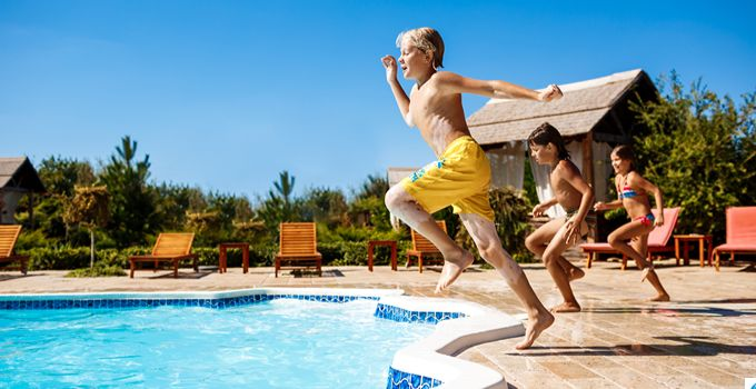 Enfants sautant dans une piscine en camping