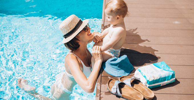 Mère et jeune enfant au bord d’une piscine ensoleillée