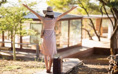 Personne avec bras ouverts au lever du soleil devant mobil home