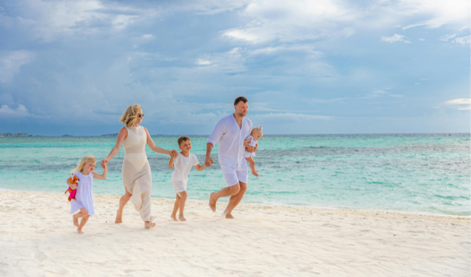 Famille marchant sur une plage lors de vacances de proximité dans un camping proche de la mer