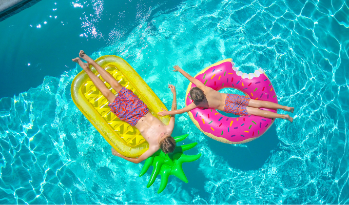 Enfants profitant d’une piscine sur des bouées colorées pendant des vacances en camping en famille